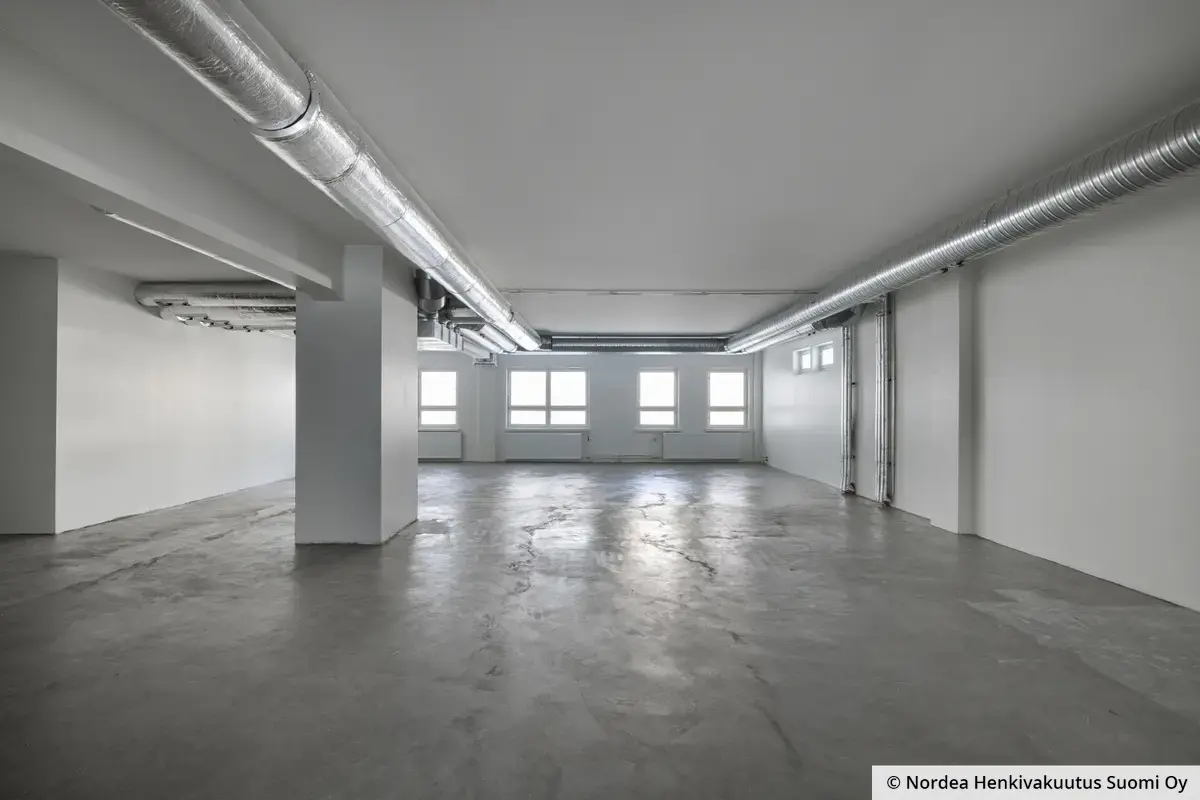 Helsingin Kiviaidankadulla tyhjä hallimainen toimistotila 203 m2, 3. kerros. Lattia on betonipintainen, seinät valkoiset ja katossa näkyy talotekniikkaa.