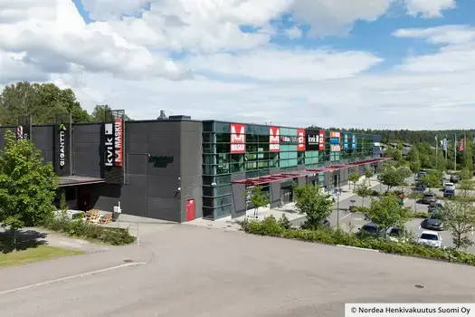 Espoon Retail Park Glomson toimitilakiinteistön parkkipaikalla on paljon vihreitä puita ja pensaita.