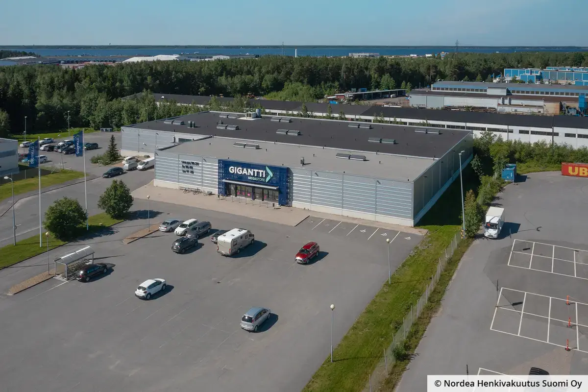 Oulun Kallisensuora 12 on harmaa toimitilakiinteistö. Kiinteistön edessä on iso parkkialue.