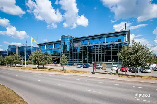 Toimitilakiinteistö Turku High Tech Centre 2, jonka julkisivu on kokonaan lasia. Talon edessä on bussipysäkki.
