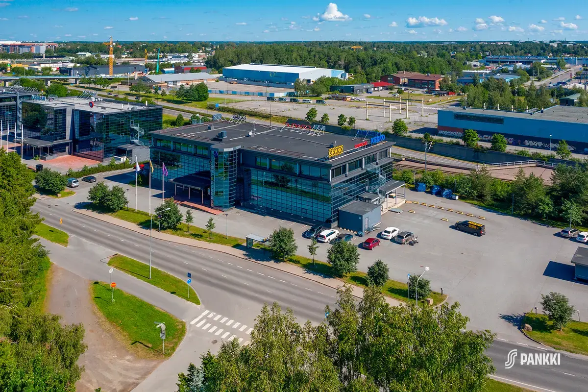 Toimitilakiinteistö Turku High Tech Centre 2 ilmasta kuvattuna. Tasakattoisen rakennuksen katolla on valomainoksia.