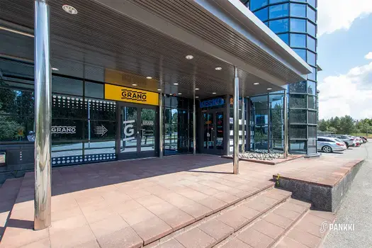 Turku High Tech Centre 2:n katettu sisäänkäynti pihalta toimitiloihin. Ovien edessä on punertava laatoitus.