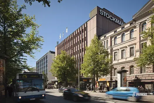 Tampereen Hämeenkadun katuympäristöä Stockmannin edustalla. Kadulla kulkee autoja, ihmisiä ja pyöräilijöitä.
