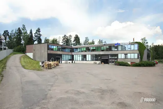 Tasakattoinen, kaksikerroksinen toimitilakiinteistö, jonka takana on puita.