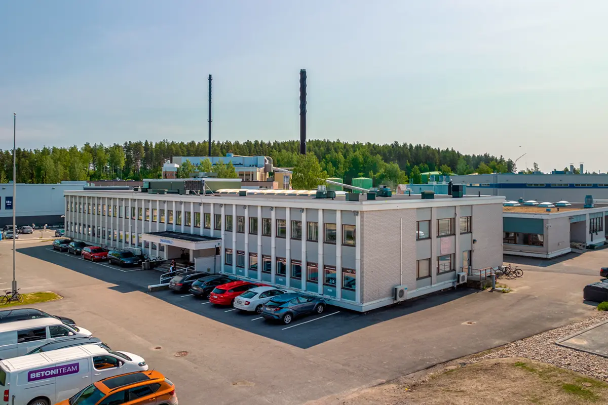 Jyväskylän Onkapannu 2 toimitilakiinteistö. Tasakattoisen, kaksikerroksisen rakennuksen vieressä on pysäköintipaikkoja. Taustalla näkyy puita.