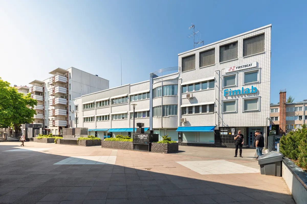 Jyväskylän Yliopistonkatu 28 toimitilakiinteistön Telefooninkujan puoleinen julkisivu. Rakennuksen edessä on tori.