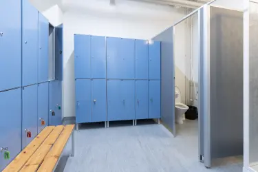 Toimiston neuvotteluhuoneessa on iso kokouspöytä ja 15 tuolia sen ympärillä. Screen on kiinnitetty seinälle.