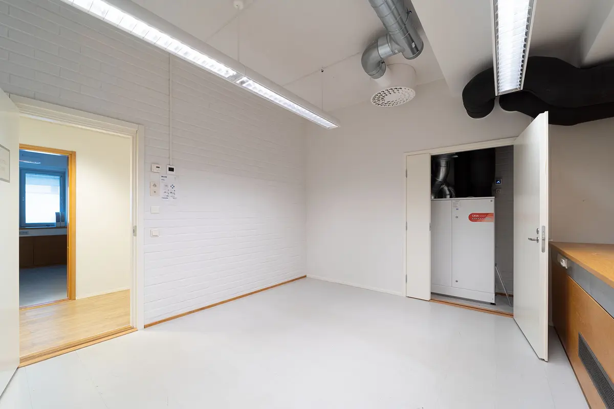 Jyväskylän Yliopistonkatu 28 ensimmäisen kerroksen 193 m2 toimitilan toimistohuone, jossa oven takana ilmanvaihtokone.