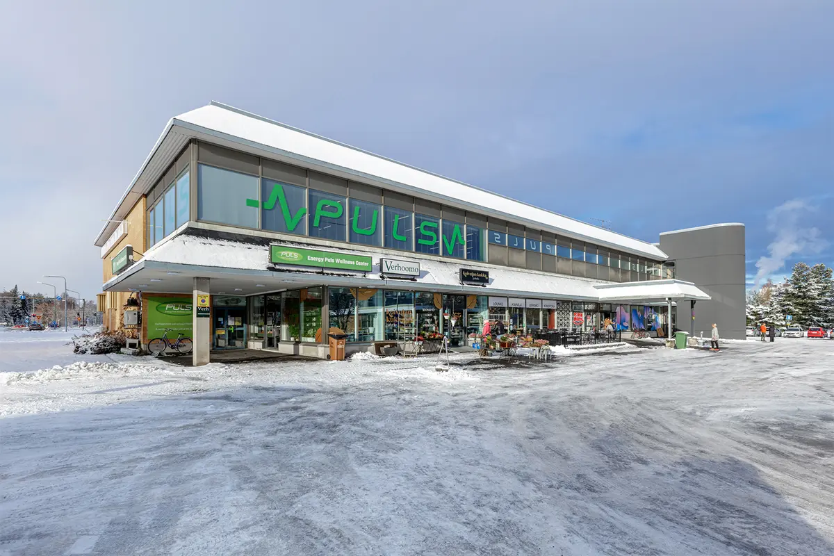 Kaksikerroksinen liikerakennus Porin Herralahdenraitti 1. Katutasossa eri liiketilojen sisäänkäyntejä, toisessa kerroksessa kuntosali.