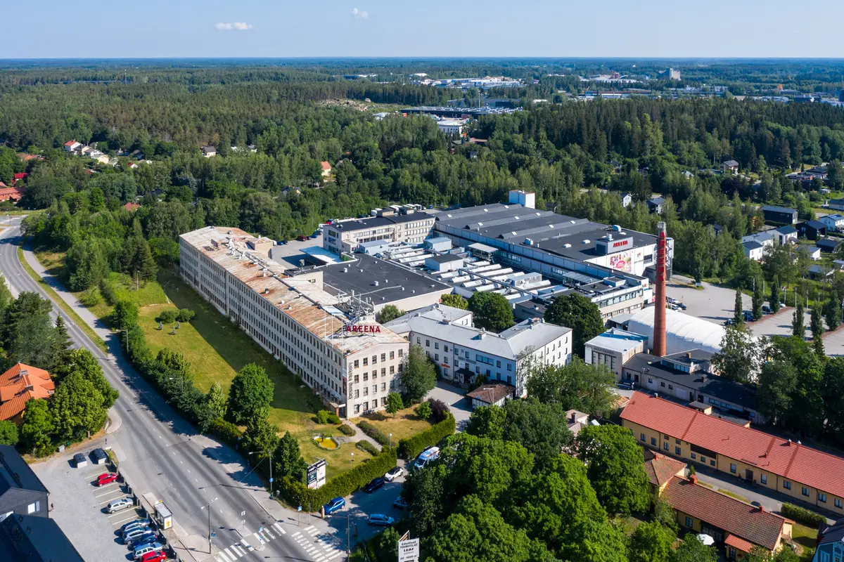 Leaf Center toimitilakiinteistö, jonka ympärillä on vehreitä puita ja muita rakennuksia.