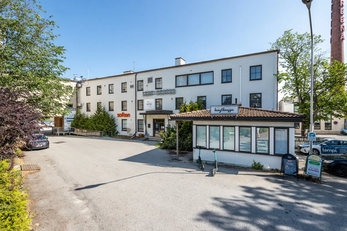 Leaf Centerin vaalea julkisivu, jonka edessä on asfaltoitu piha-alue.
