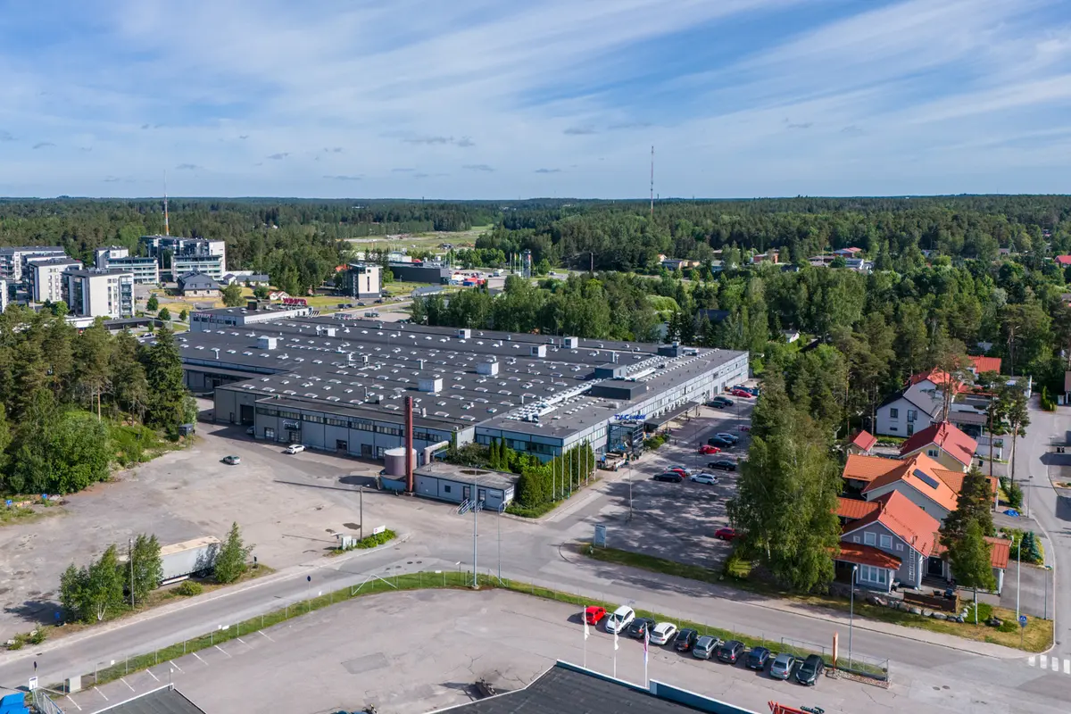 TV-Center toimitilakiinteistö kuvattuna ylhäältä. Kiinteistön ympärillä on asfaltoitu piha sekä vehreitä puita.