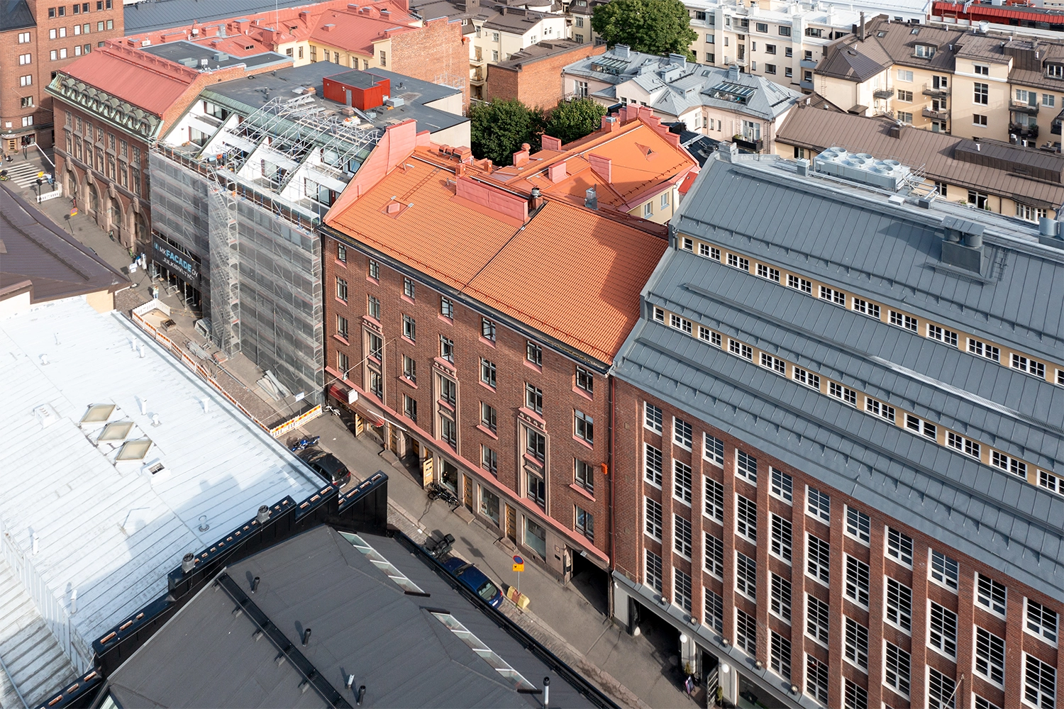 Helsingin Kalevankatu 28 oranssi kattoinen asuinkiinteistu00f6 ilmakuvassa. Rakennuksen kivijalassa liiketiloja.