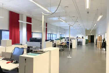 Meiramitie 3, Vantaa 2398 m2 toimitilan sisäkuva. Toimistotila jossa vasemmalla reunalla, ikkunoiden vieressä monta työpistettä rivissä. Oikeaa seinää pitkin kulkee käytävä.