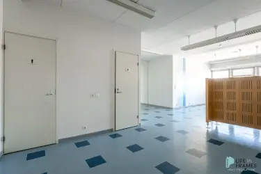 Bright business premises at Lauttakylänkatu 4 in Huittinen, where the open space is divided by a wooden screen. On the wall there are doors to the toilets.