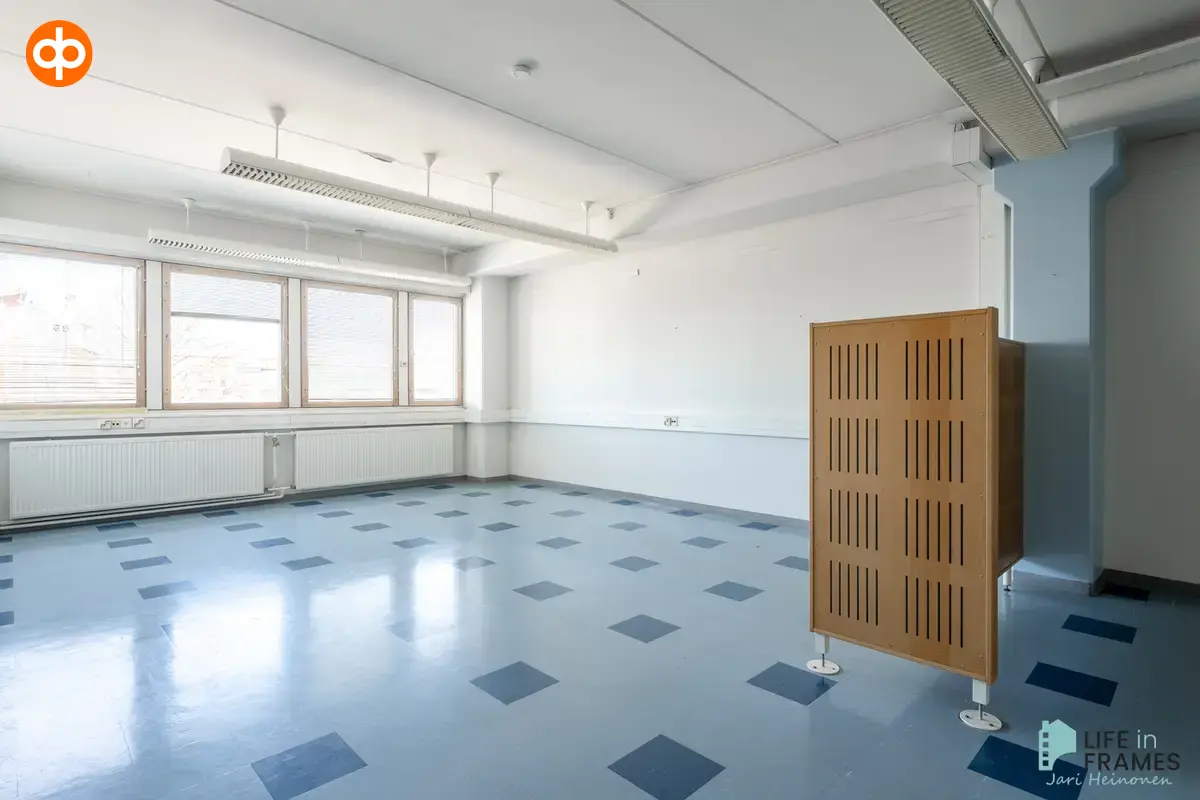 Tidy second floor open space at Lauttakylänkatu 4 in Huittinen. Light blue tiles on the floor with darker blue tiles in the midst.