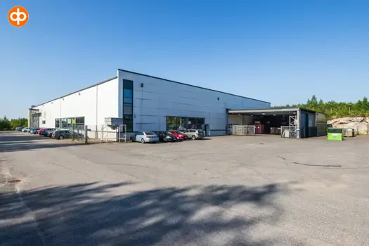 Järvenpää's Tempo 4, an exterior view of the business premises. A boxy white building. Surrounded by cars parked in an asphalted yard.