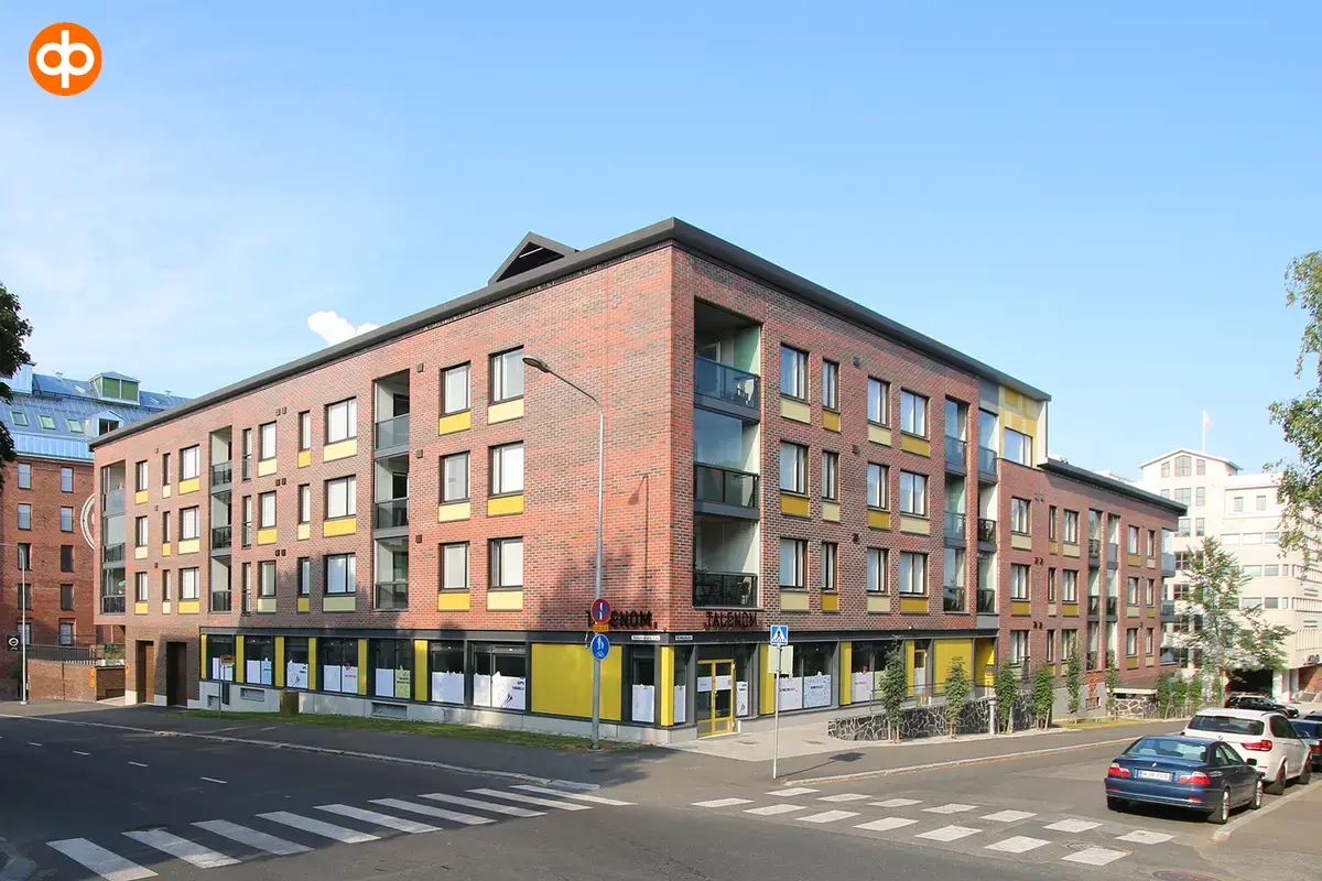 Kuopio Satamakatu 13 a, exterior view of the office property. A red brick multi-storey residential building. Commercial premises at street level.