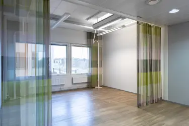 Alberga Business Park – D- ja E-talot, 3. kerroksen 372,5 m2 toimitilan sisäkuva. Tyhjä toimistohuone, jossa puiset lattiat ja vaaleat seinät. Tilan keskellä verhot. Takaseinällä ikkunat
