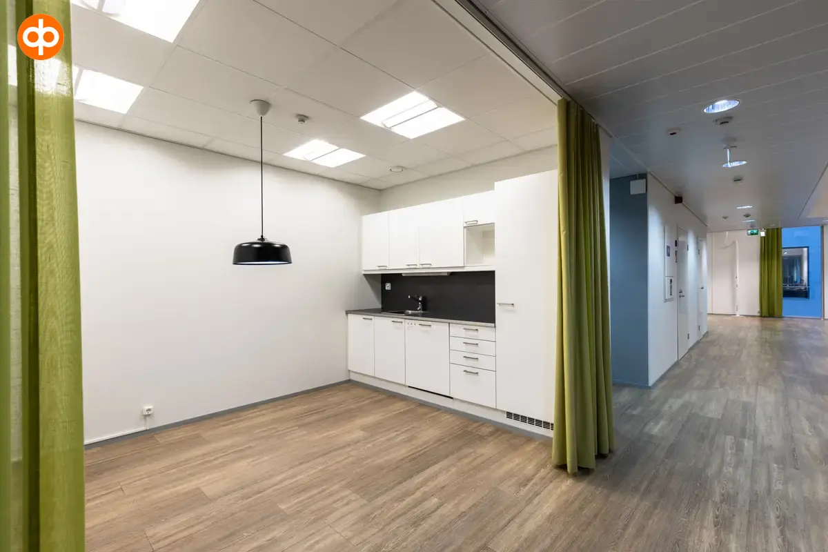 Alberga Business Park – D and E buildings, interior view of the 372.5 m2 office space on the 3rd floor. Alcove with a small kitchen with light cabinets. Curtains in front of the alcove. 