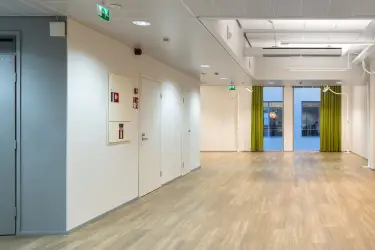 Alberga Business Park – D and E buildings, interior view of the 372.5 m2 office space on the 3rd floor. Empty open-plan office. Wooden floors and white walls. Two doors on the left wall.