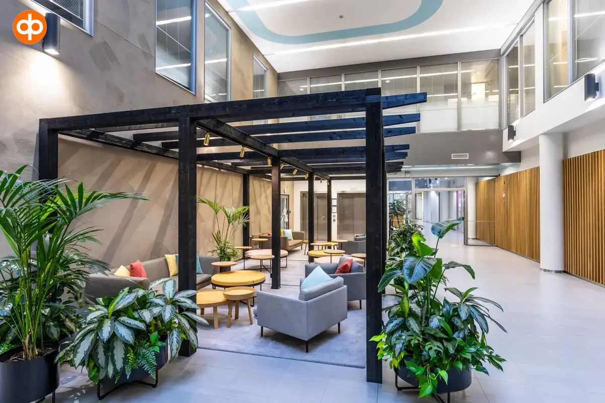 Alberga Business Park, interior view of the office property. Lounge area with groups of sofas surrounded by plants.