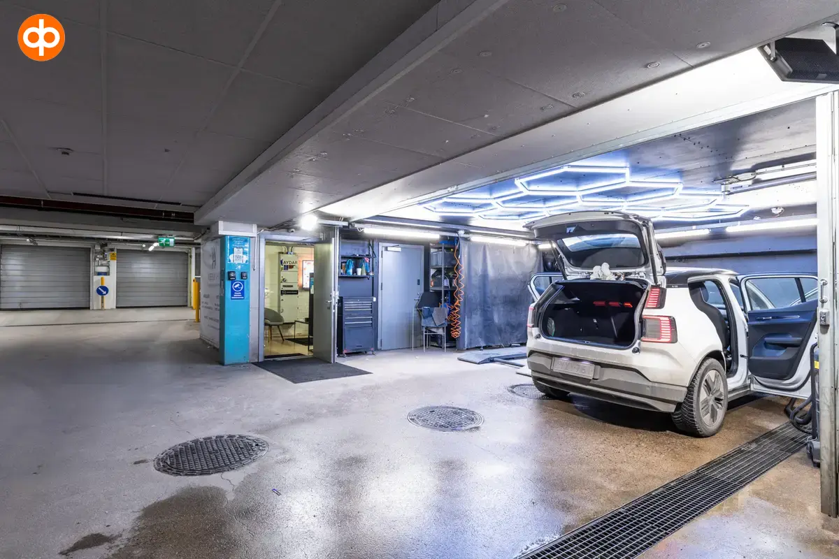 Alberga Business Park – D and E buildings, interior view of the parking garage of the business premises. Car wash and repair corner located in the hall. Car parked in the corner with all doors open