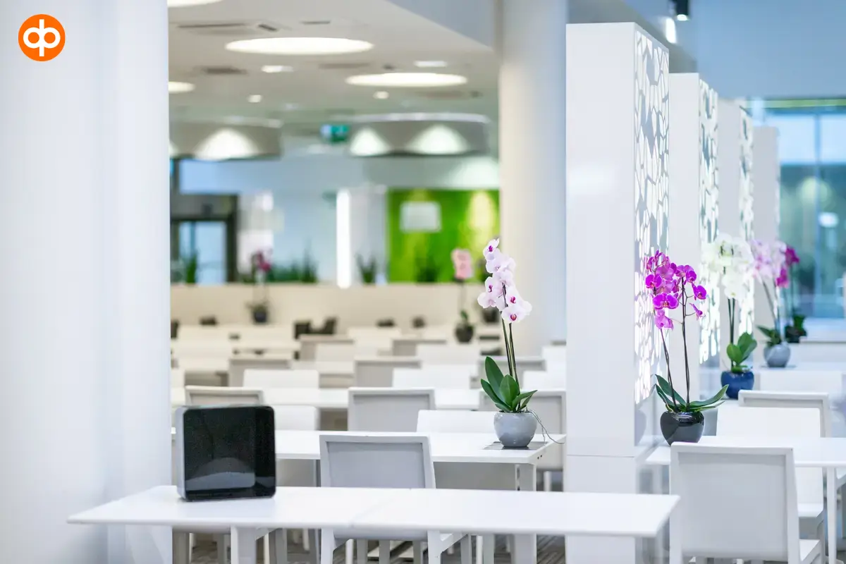 Alberga Business Park, office property dining hall. White tables with orchid flowers in pots.