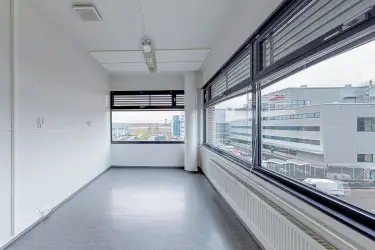 Vantaan Martinkyläntie 17, 3. kerroksen 865 m2 toimitilan sisäkuva. Tyhjä toimistohuone, jossa kahdella seinällä suuret ikkunat ulos, pinnat vaaleat.