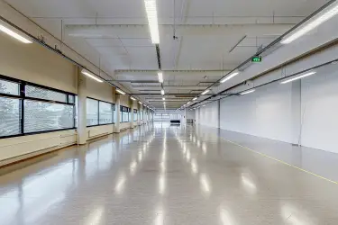 Vantaan Martinkyläntie 17, 3. kerroksen 865 m2 toimitilan sisäkuva. Tyhjä avotila, jossa vasemmalla seinällä useampi ikkuna. Lattiat ja seinät vaaleat.