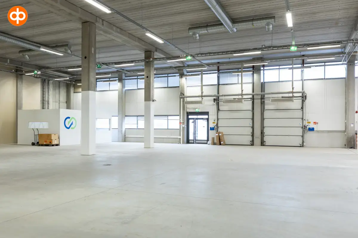 Vantaa Silvastintie 1, interior view of the premises. An empty warehouse with two lifting doors and one glass door next to them. The premises have light surfaces.