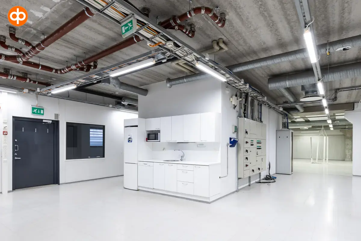 Vantaa Silvastintie 1, interior view of the office. Kitchen with white cabinets. Empty, light-surfaced space all around.