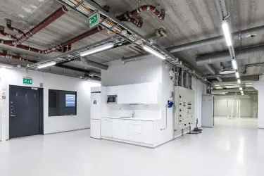 Vantaa Silvastintie 1, interior view of the office. Kitchen with white cabinets. Empty, light-surfaced space all around.
