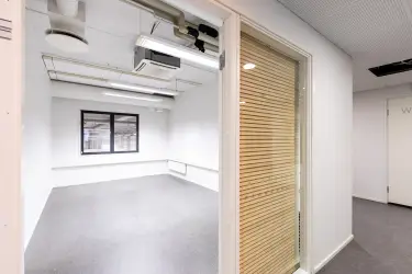 Interior view of the 3278 m2 office space on the 1st-2nd floor, Silvastintie 1, Vantaa. Empty office room with a window facing the street. There is a window on the back wall that shows the storage spa