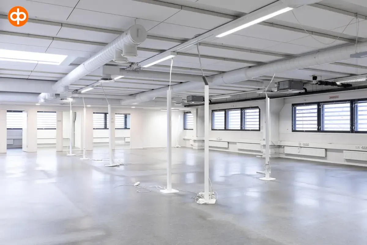 Interior view of the office space on the 2nd floor at Silvastintie 1, Vantaa. Empty open-plan office space with light surfaces, windows on the right wall, two separate office rooms behind open space.