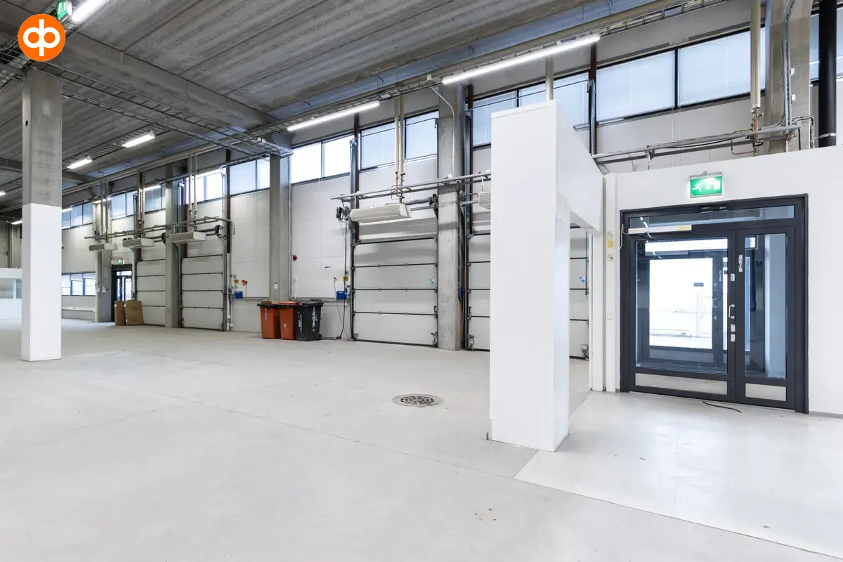 Interior view of the office space on the 1st floor, Silvastintie 1, Vantaa. On the left side, a glass door to the outside. Next to the door, several lifting doors side by side.