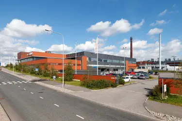 Silvastintie 1, Vantaa. Red brick and partly grey office building with a parking area in front. Multi-storey building, road on the left.