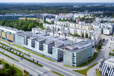 Alberga Business Park – D building photographed from the air. A large light gray property by the highway. Other buildings behind.