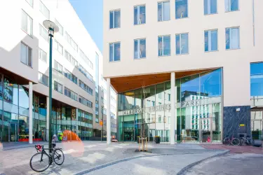 Alberga Business Park – D building facade with a large glass wall. A small square in front of the property.