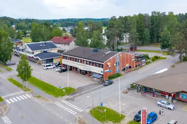 Commercial property at Asematie 7 in Pihtiputaa. There is a parking lot in front of the property and other properties around it.